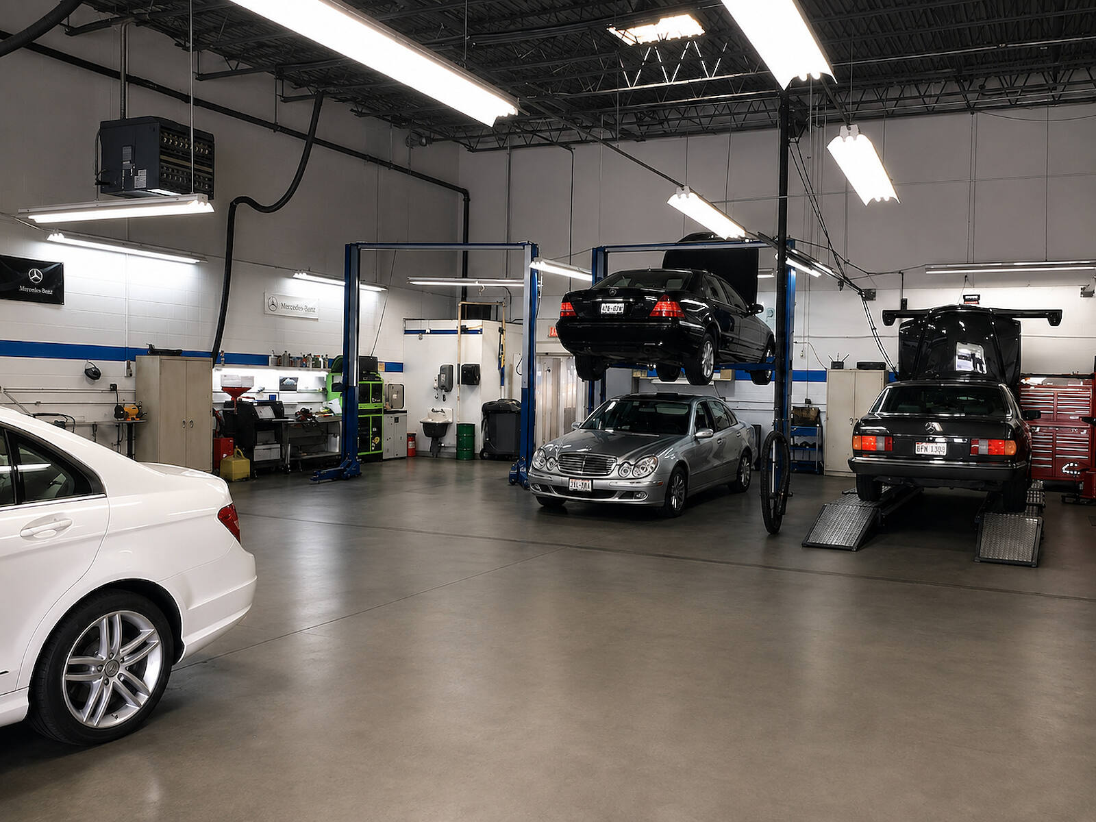 The Silver Star Motors service bay, with a Mercedes-Benz sedan and two cars on lifts