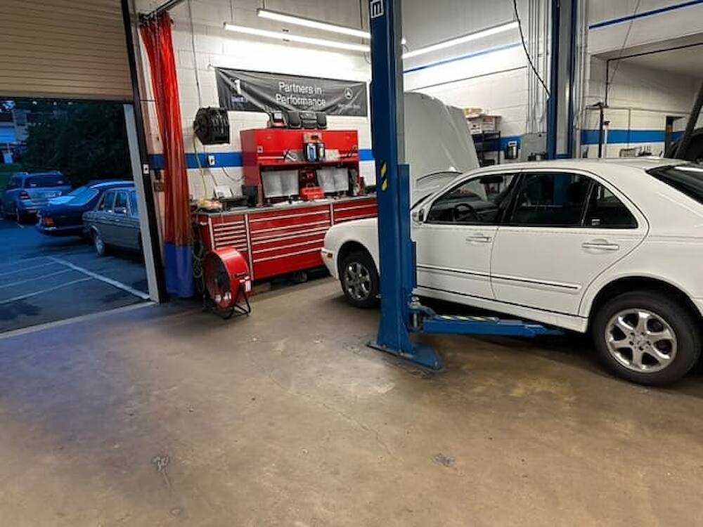 A Mercedes-Benz on the lift, seen from the bay floor