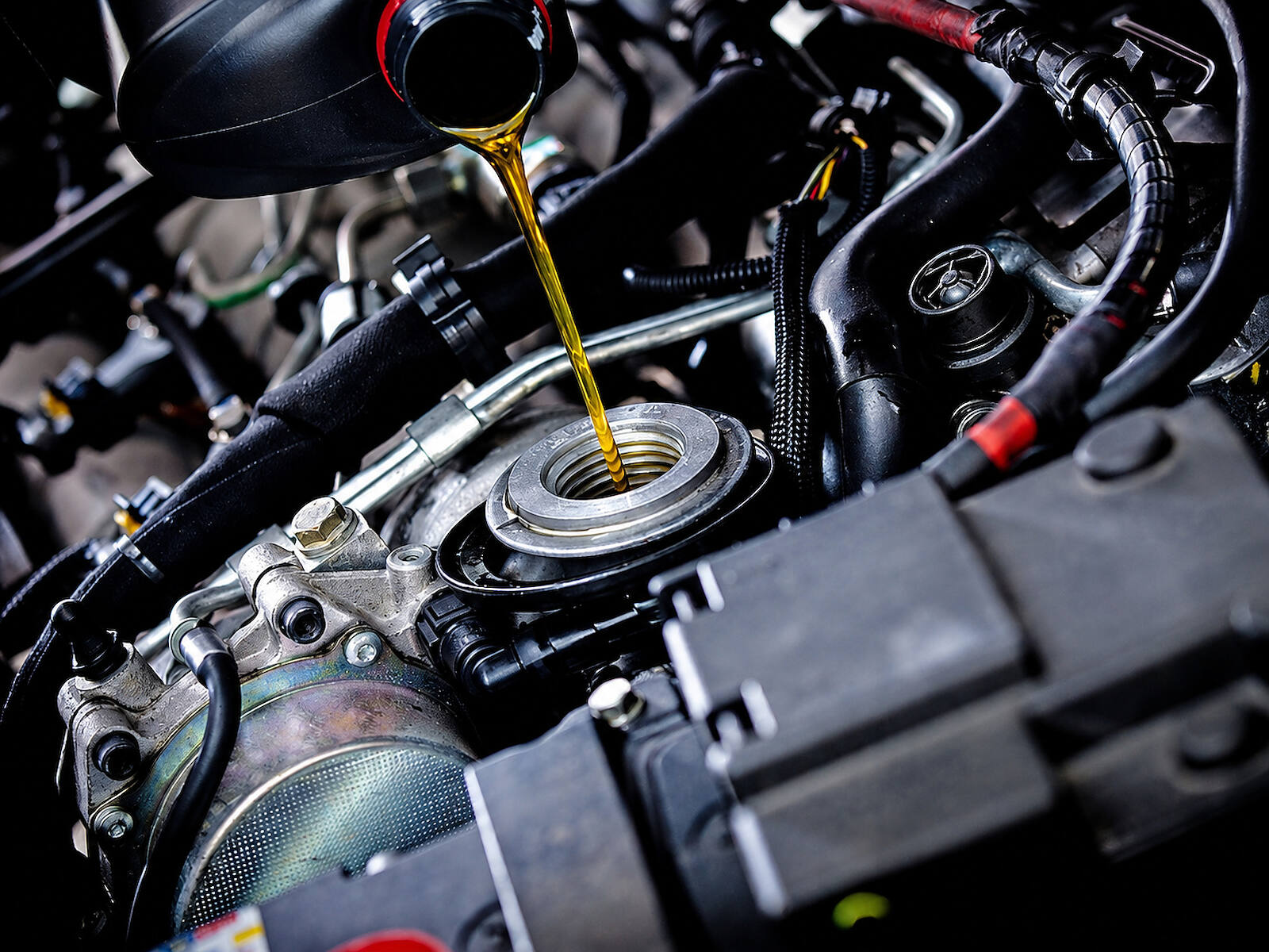 Fresh oil being poured into a Mercedes-Benz engine bay